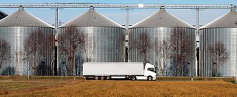 Truck in from of silos on a farm