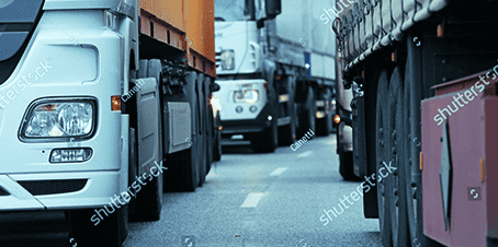 rows of semi-trucks on highway